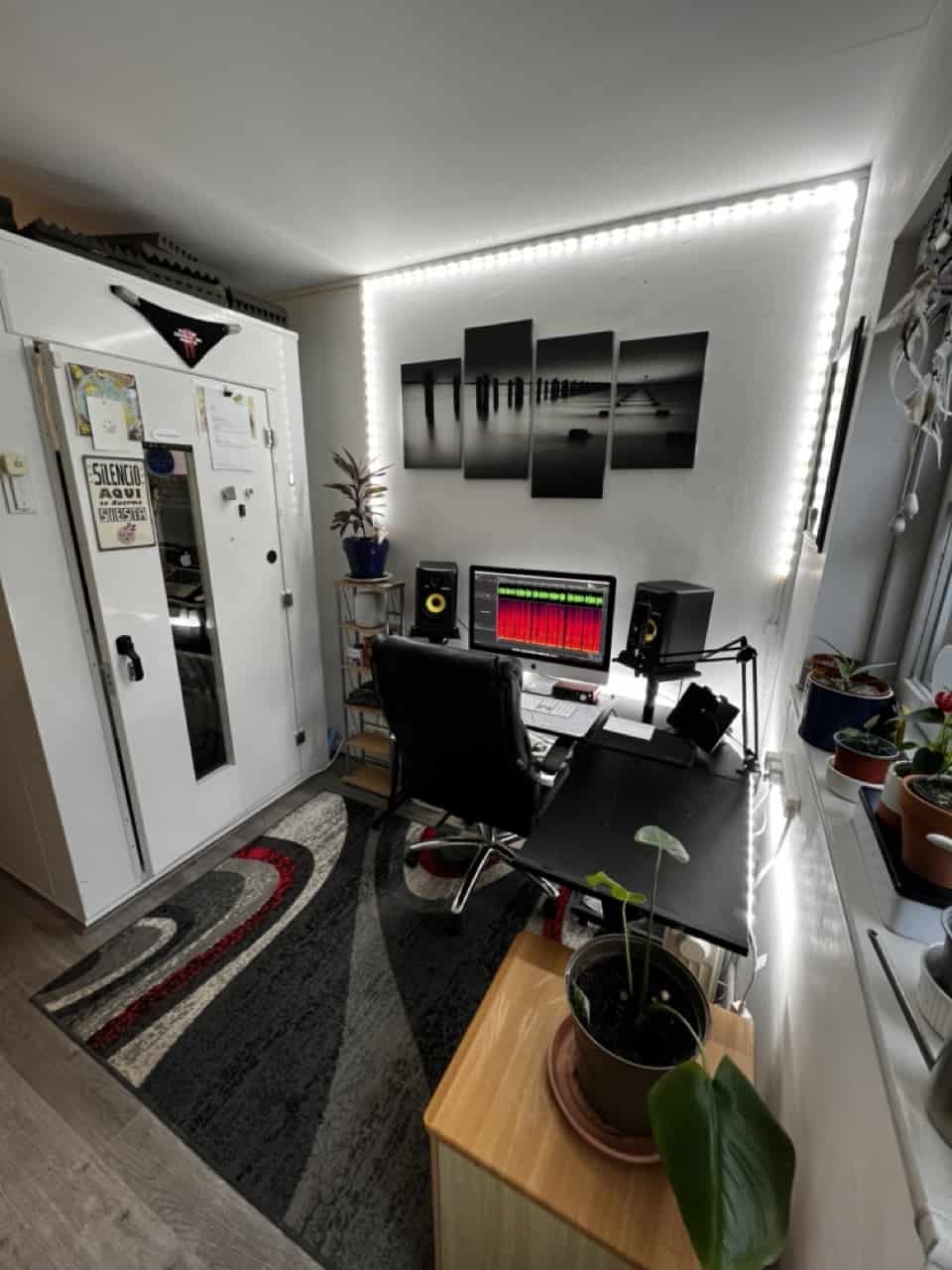 Wide angle shot of the studio of Mark Thomas, a British VoiceOver artist. There is a computer with an audio waveform showing plus two monitor speakers.